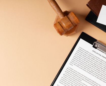 A wooden judge 's gavel is sitting on top of a clipboard with a piece of paper on it.