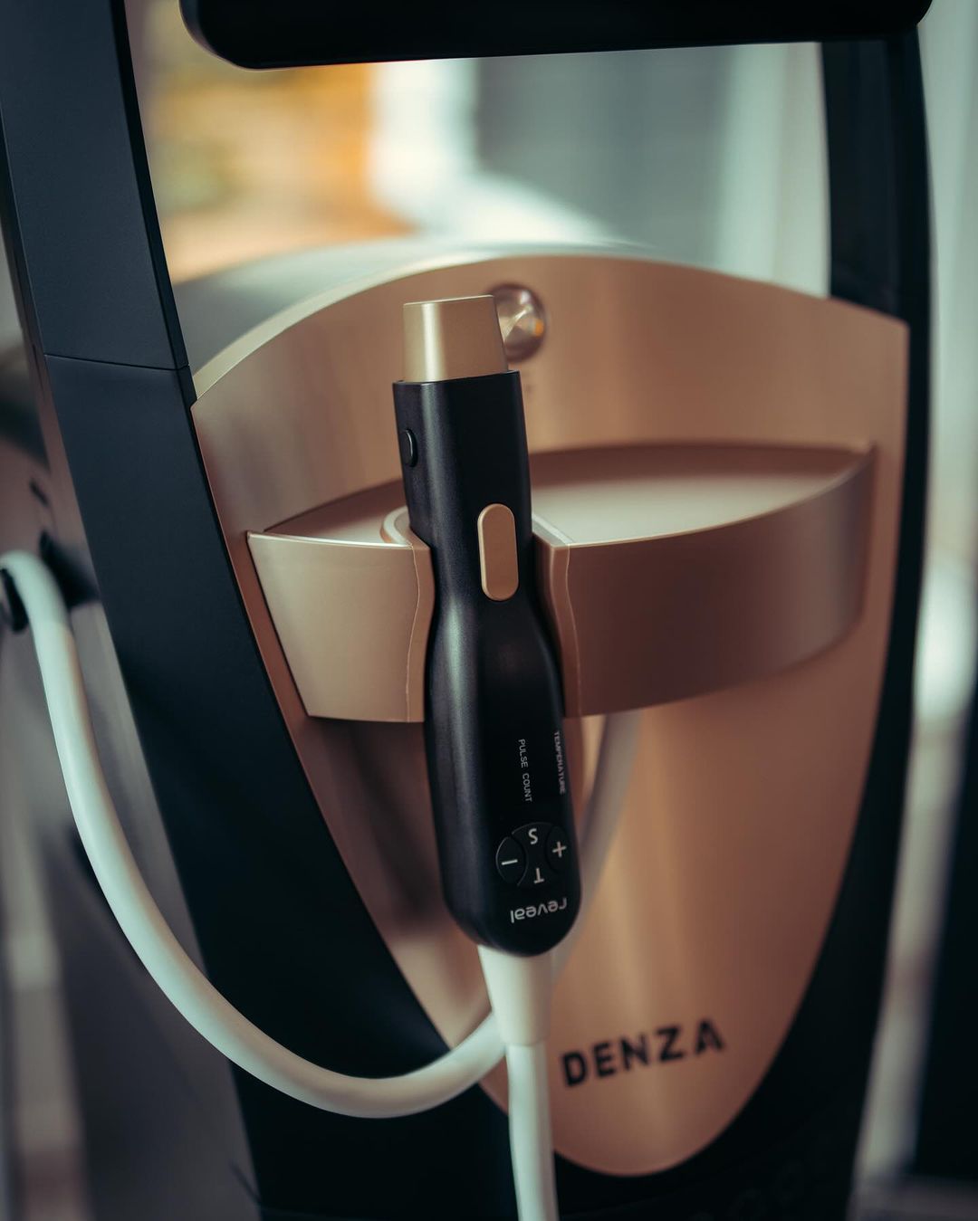 A close up of a laser skin tightening device that says ' denza ' on it