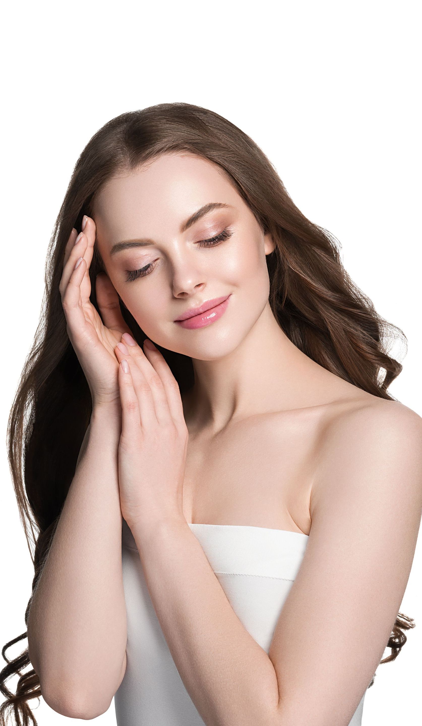 a woman with long hair is smiling and touching her face with her hands .