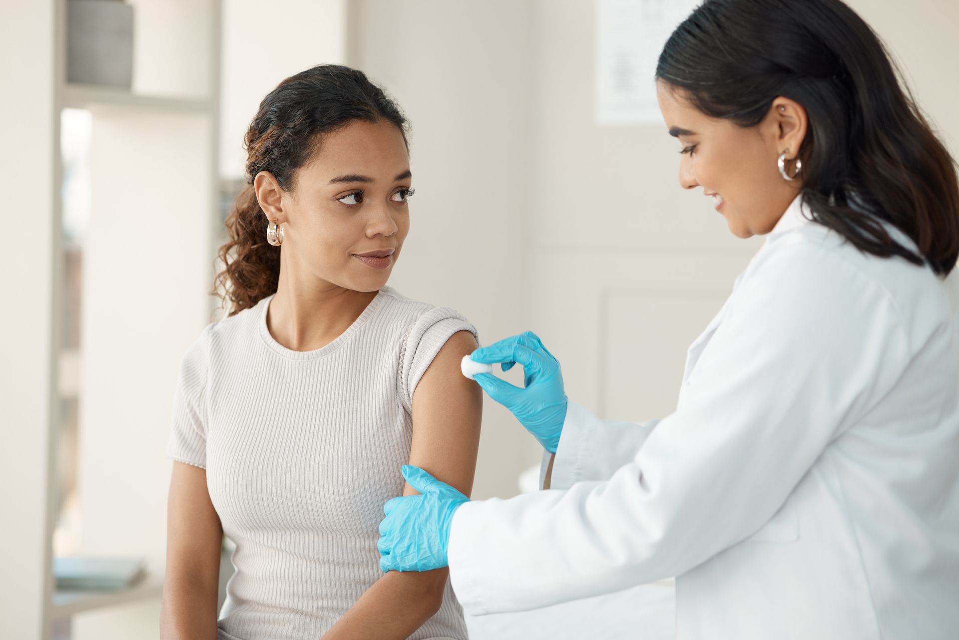 A woman is getting an injection in her arm by a doctor.