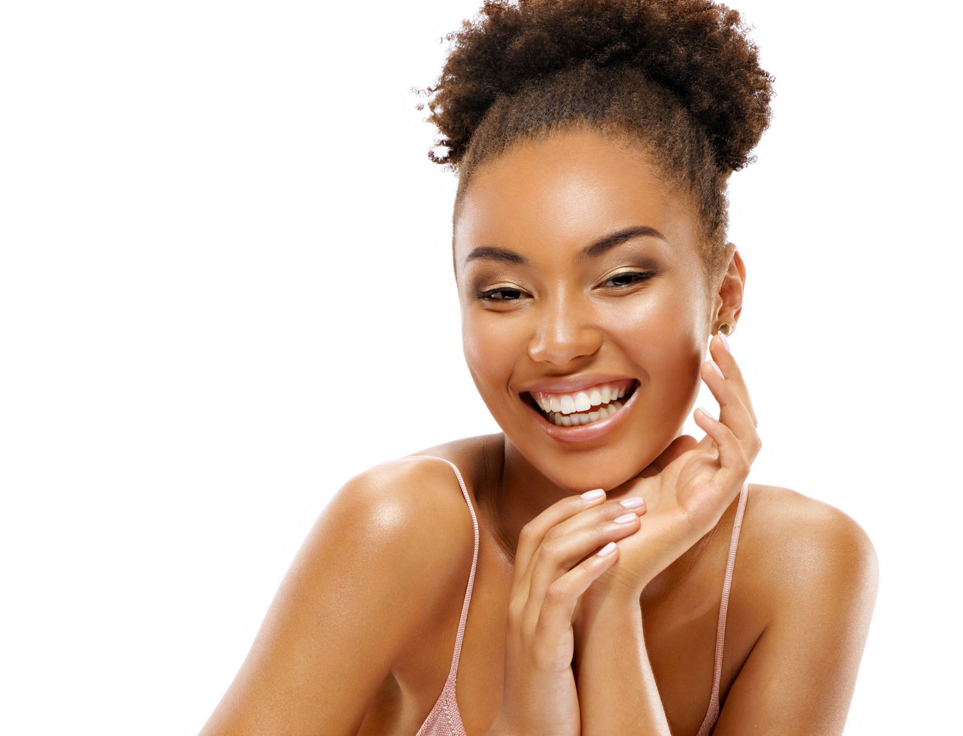 a woman is smiling and touching her face with her hands .