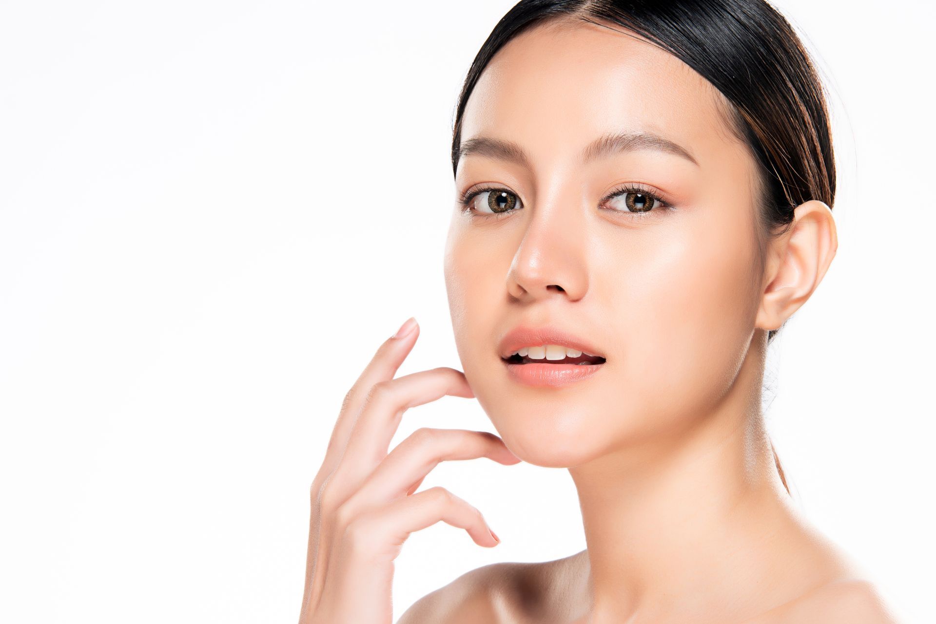 a woman is touching her face with her hand on a white background .