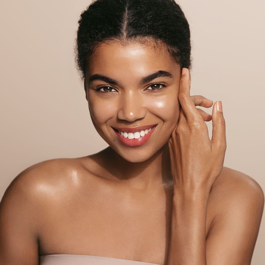 a woman is touching her face with her hand on a white background .