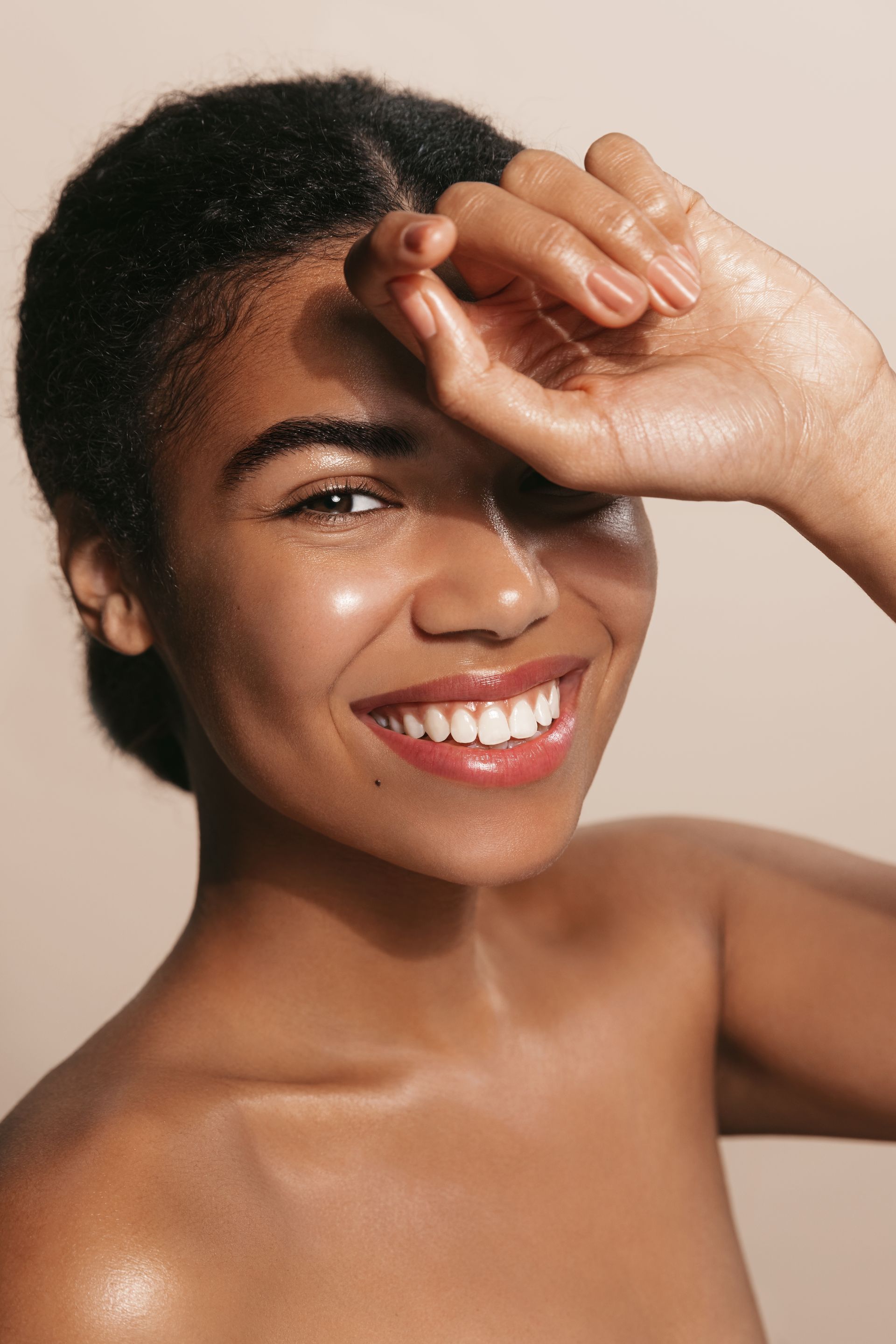 a woman is touching her face with her hand on a white background .