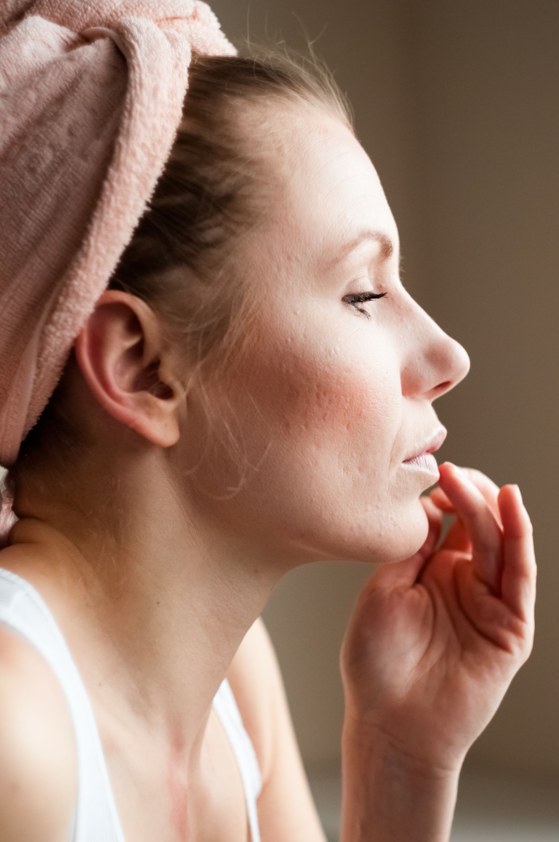 a woman with a towel wrapped around her head is looking out a window .