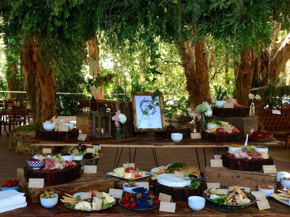 A large grazing table is surrounded by trees and bush — Amanda Douglass Catering Service in Corlette, NSW