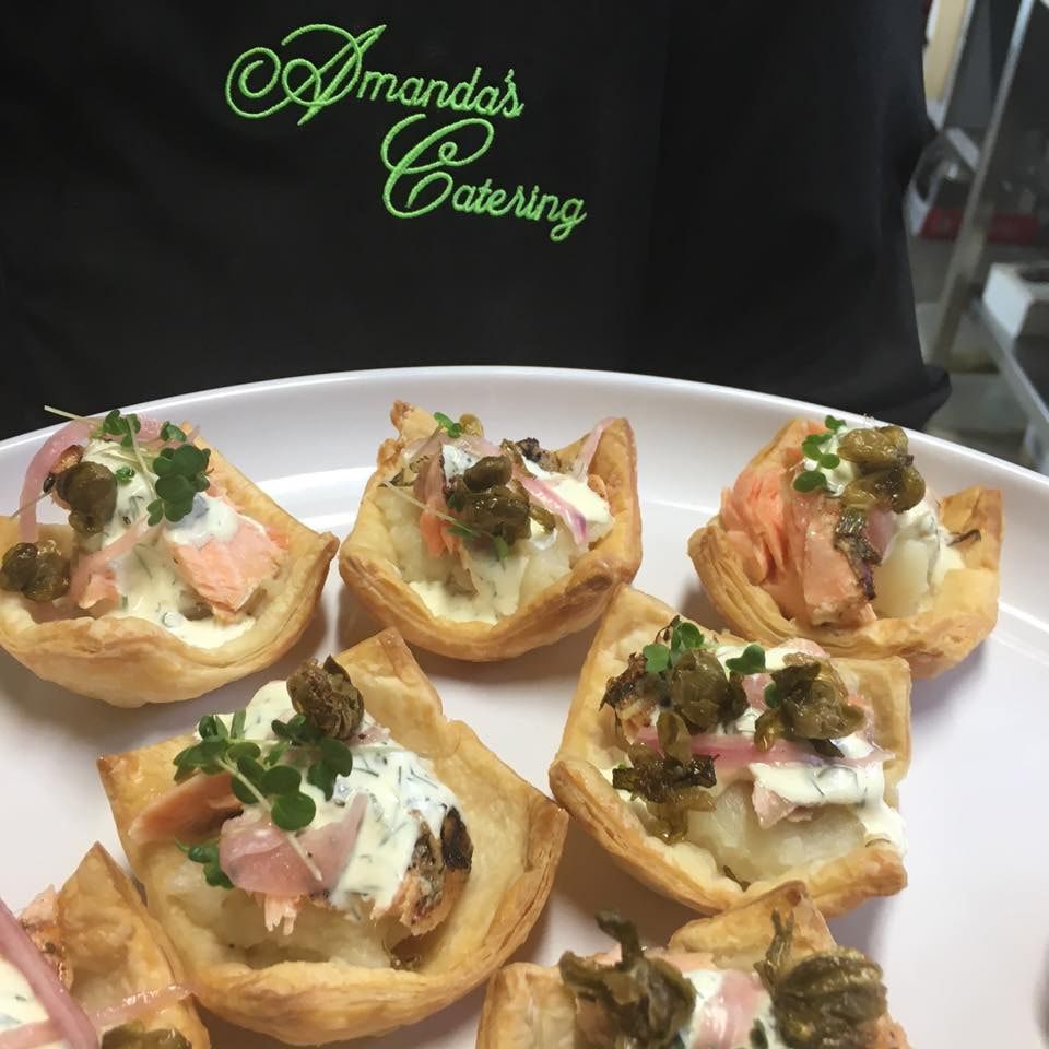 Someone wearing a Amanda Catering Apron while holding tarts— Amanda Douglass Catering Service in Corlette, NSW