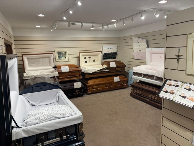 Furniture showroom with several beds and dressers displayed under track lighting