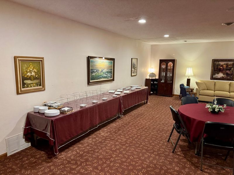 Buffet table with red tablecloth in a banquet room with framed art and seating area