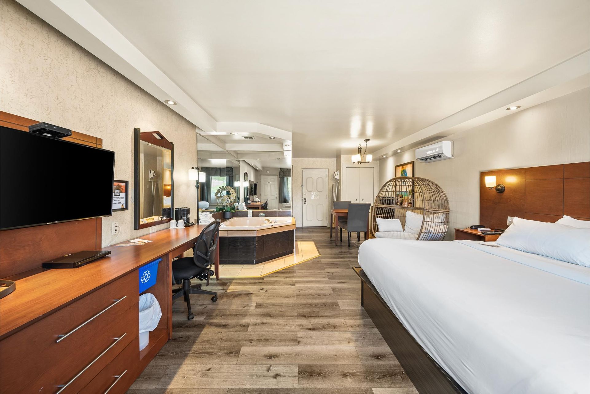 Une chambre d'hôtel avec un lit king size et un jacuzzi.