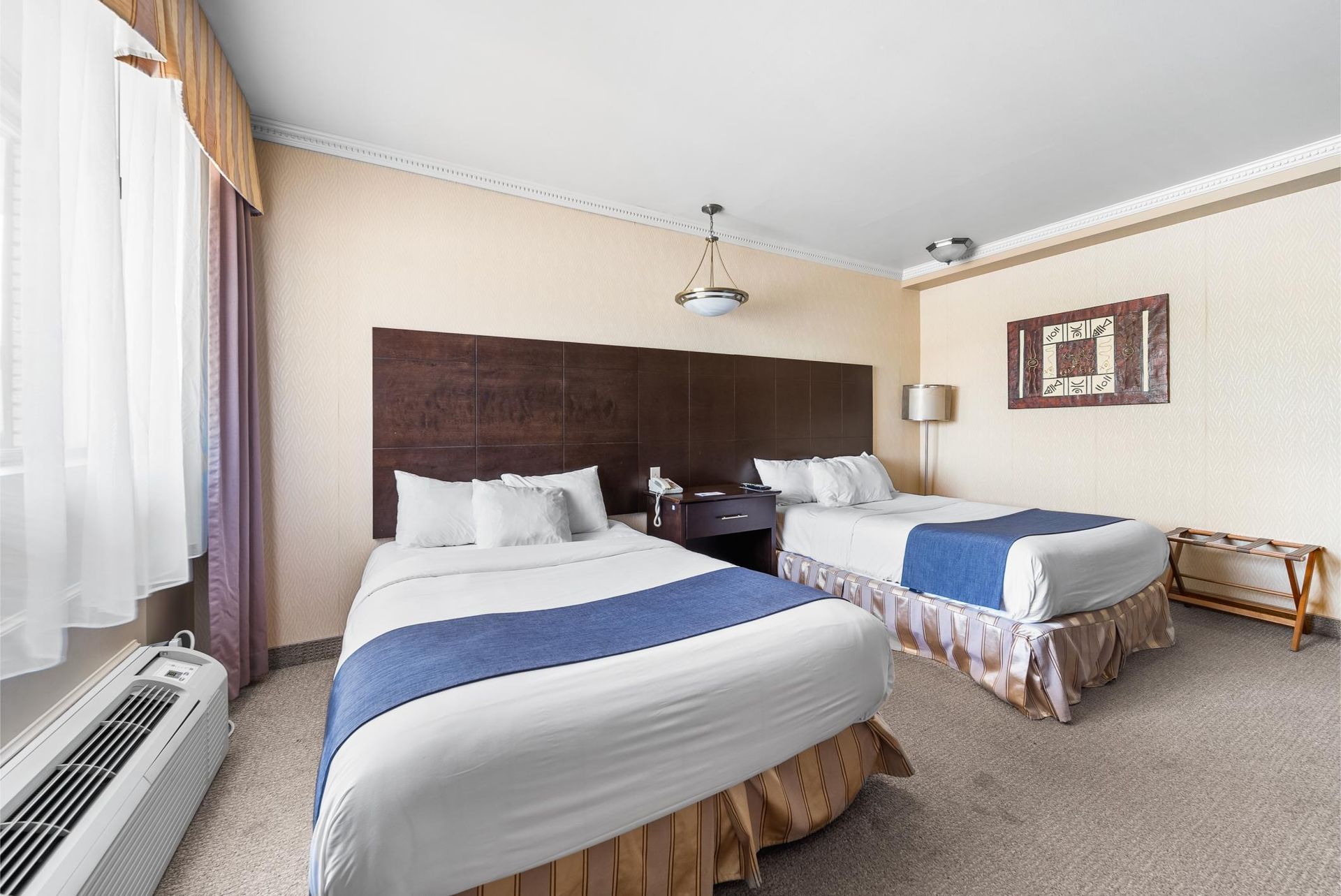 Une chambre d'hôtel avec deux lits et une fenêtre.