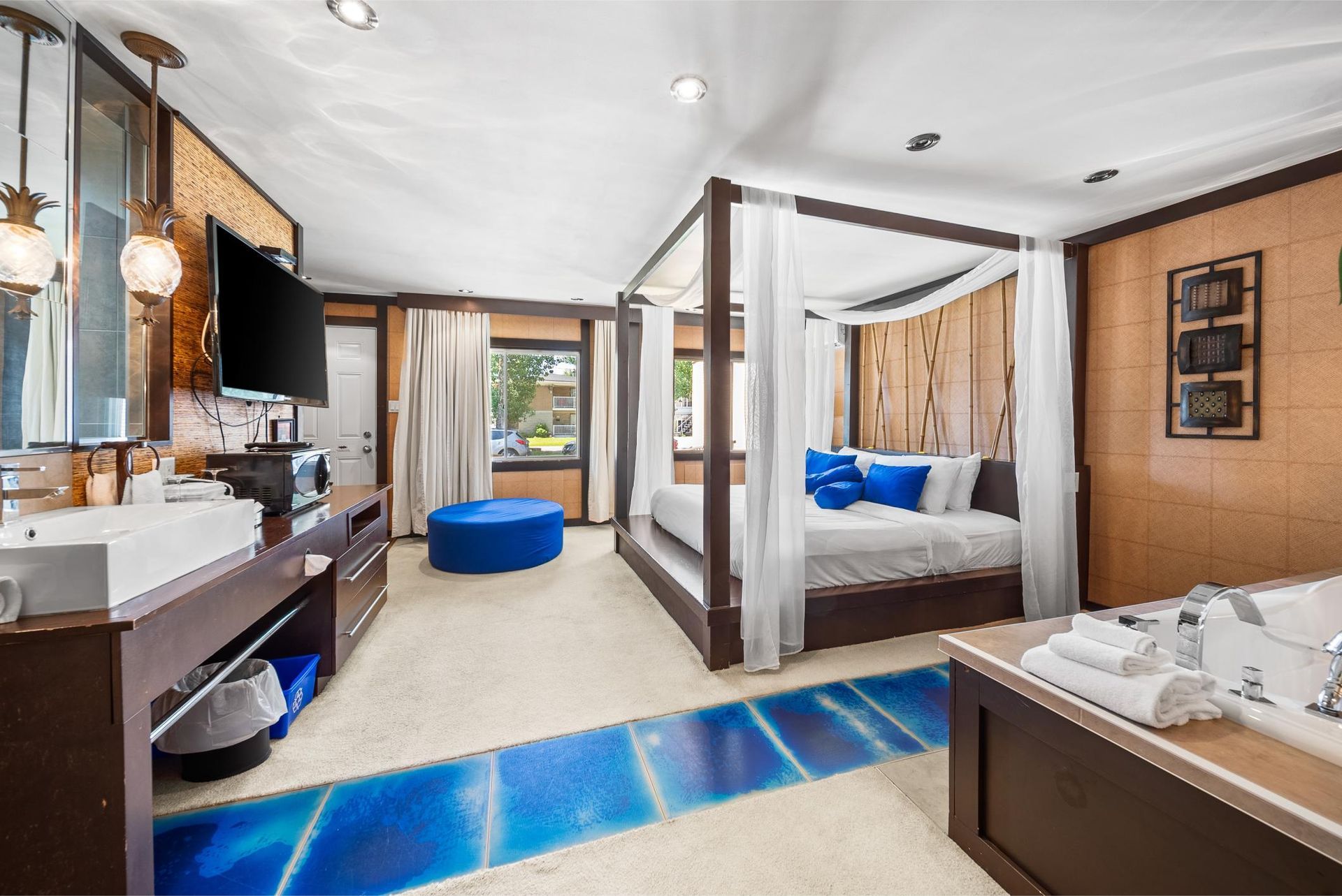 Une chambre d'hôtel avec un lit à baldaquin et une baignoire.