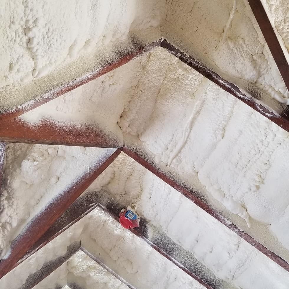 Steep staircase with white walls and red trim, viewed from above, with a small person below.