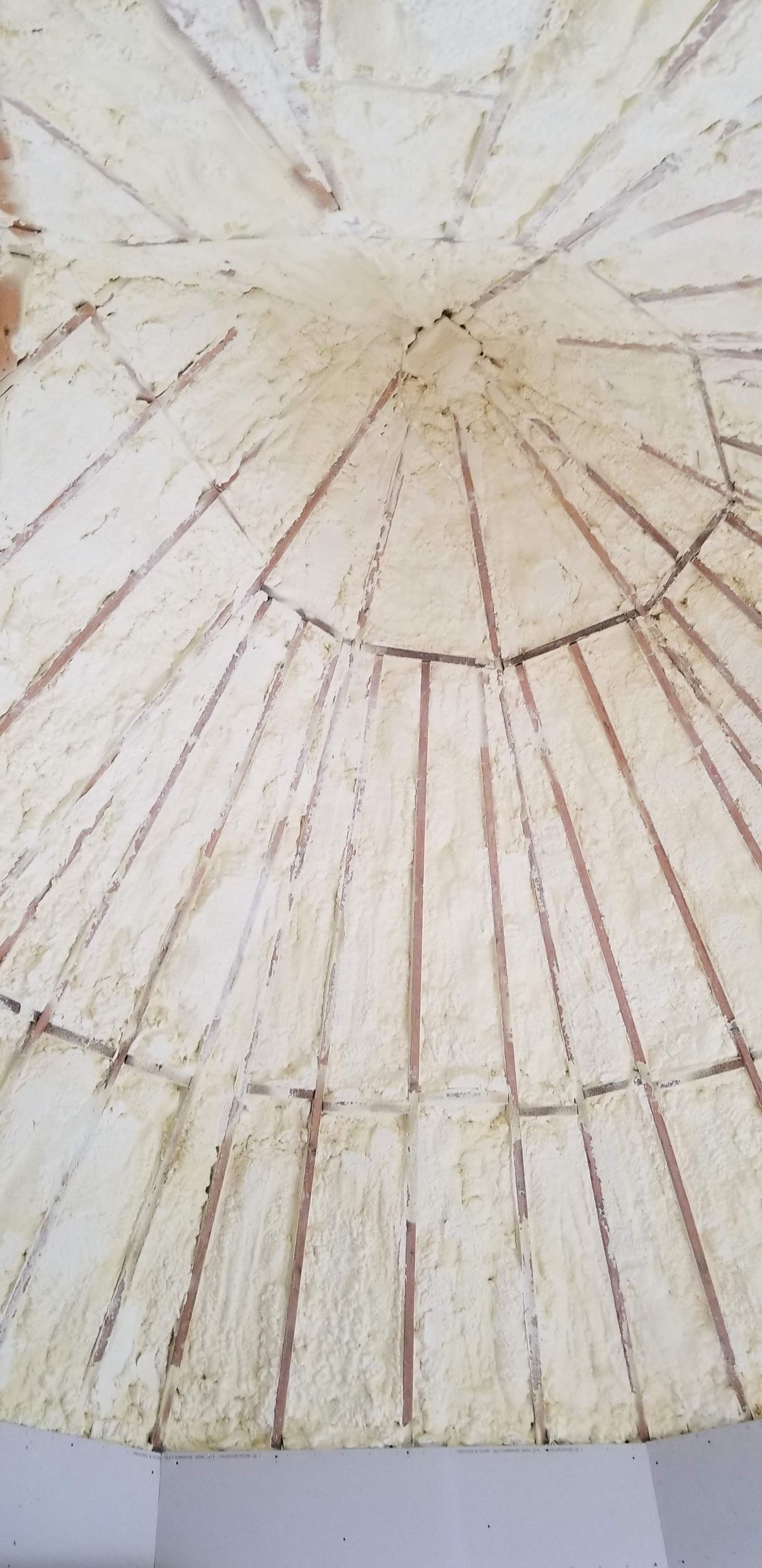 Close-up of a white, weathered ceiling with a circular crack pattern and radiating lines