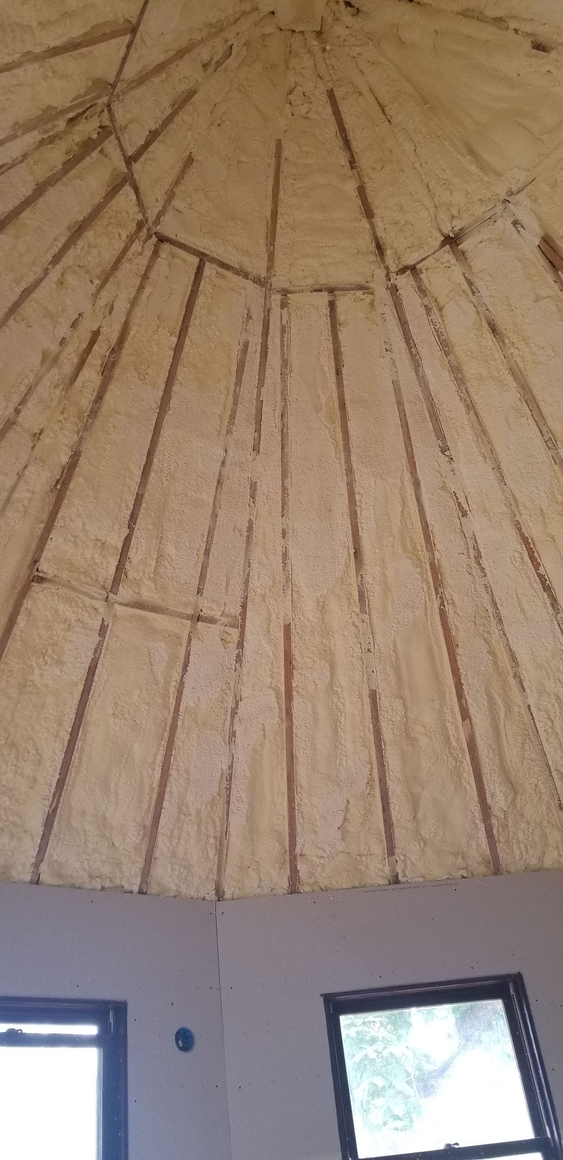 Thatched conical ceiling above two small windows in a room