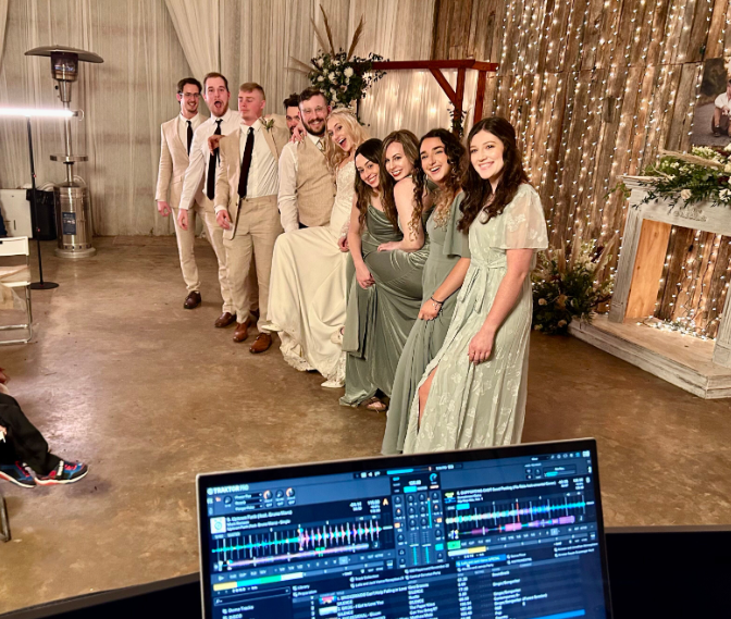bride and groom smiling with wedding party