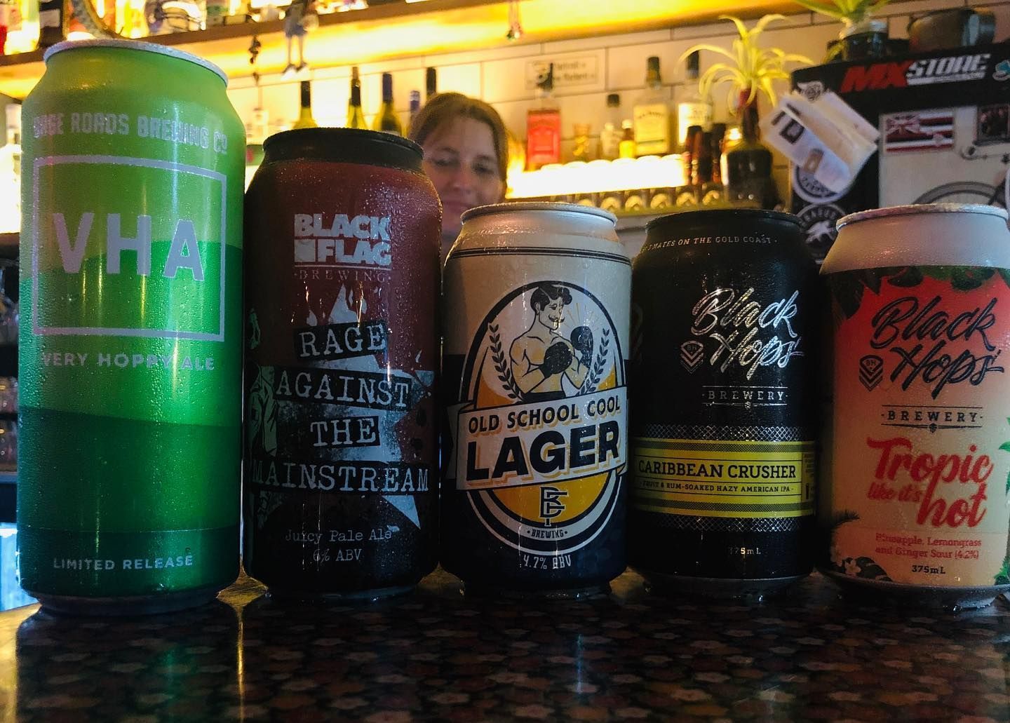 Five Beer Cans of Various Brands on a Bar Counter — Village Bicycle Noosa in Noosa Heads, QLD