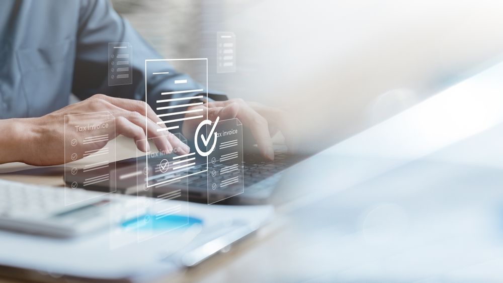 Hands typing on a laptop with a transparent security check icon overlay on a bright desk.