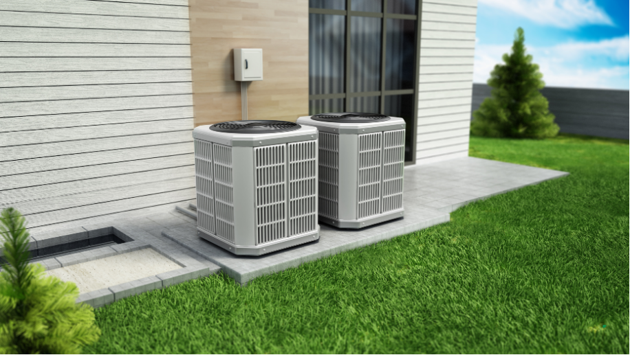 Two outdoor HVAC units beside a house on a concrete pad next to green lawn