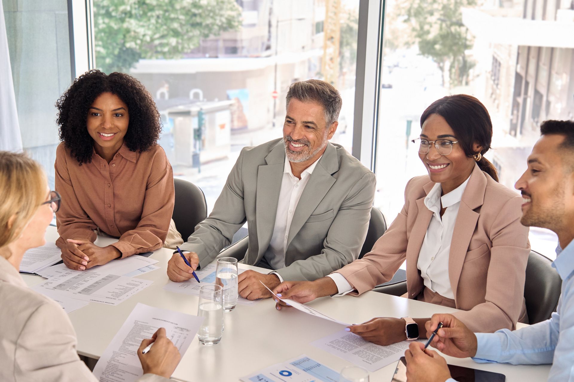 Business team in a bright conference room discussing ideas around a table.