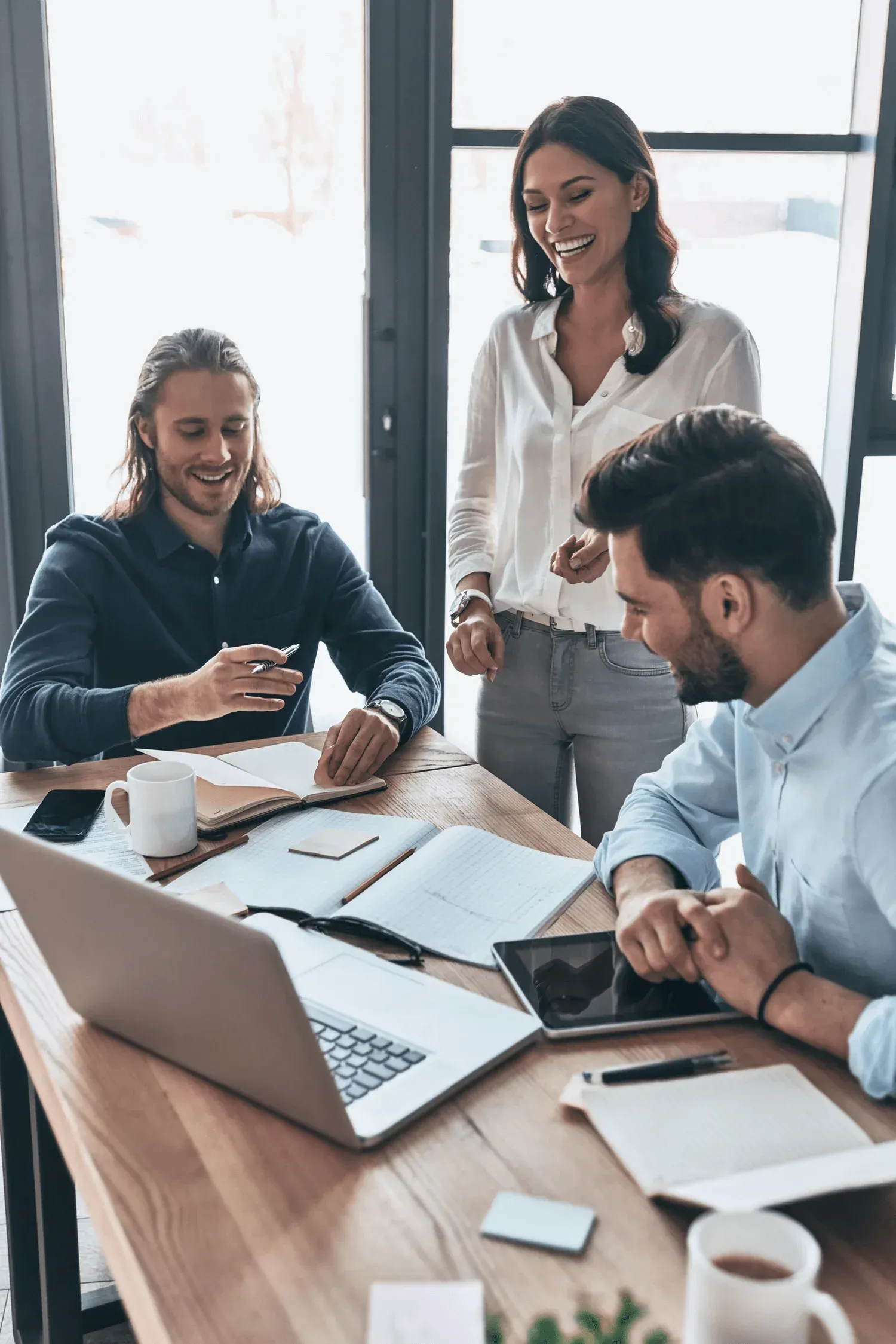drie zakelijke personen achter bureau lachen
