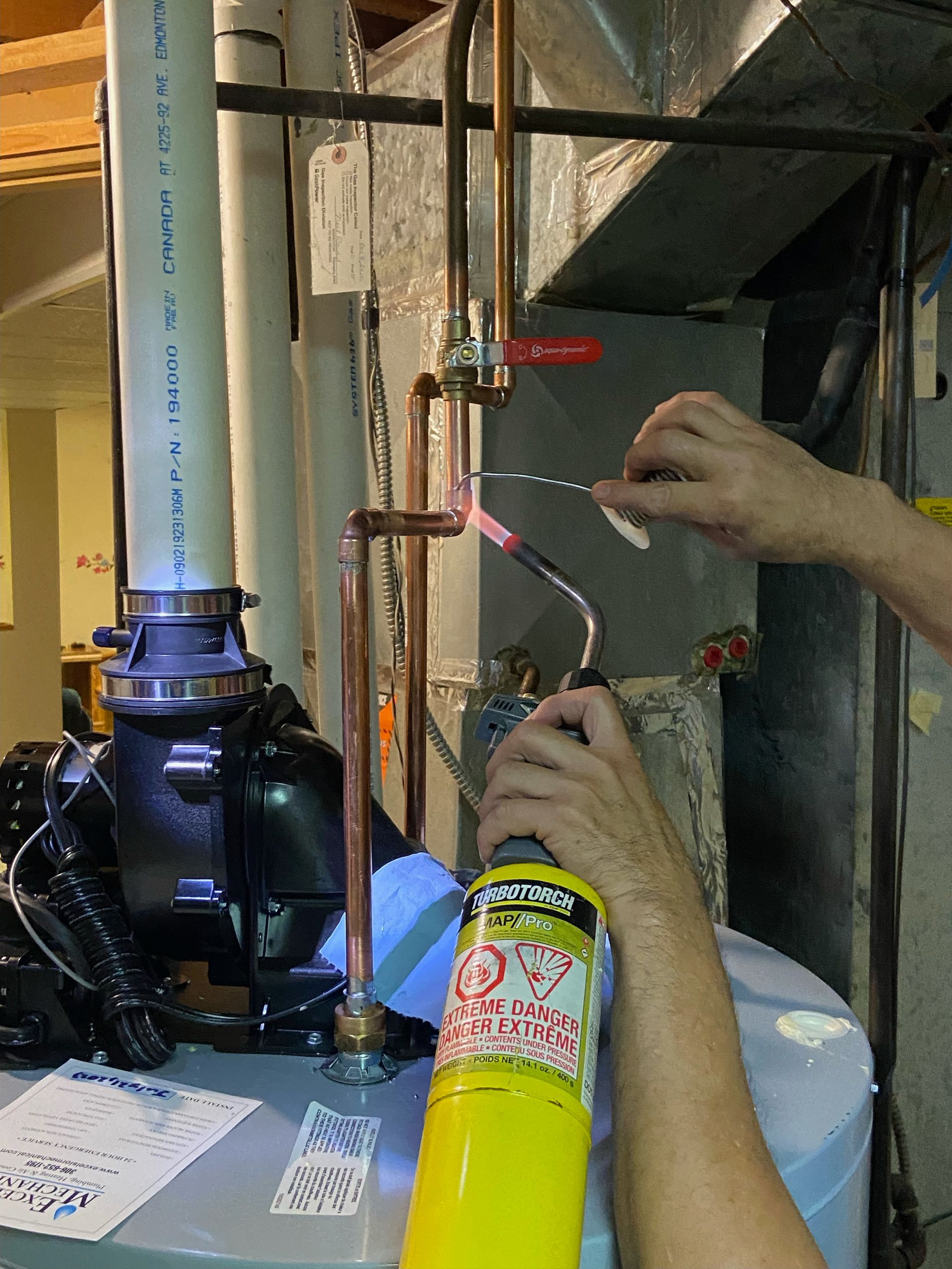 a person is working on a water heater with a torch
