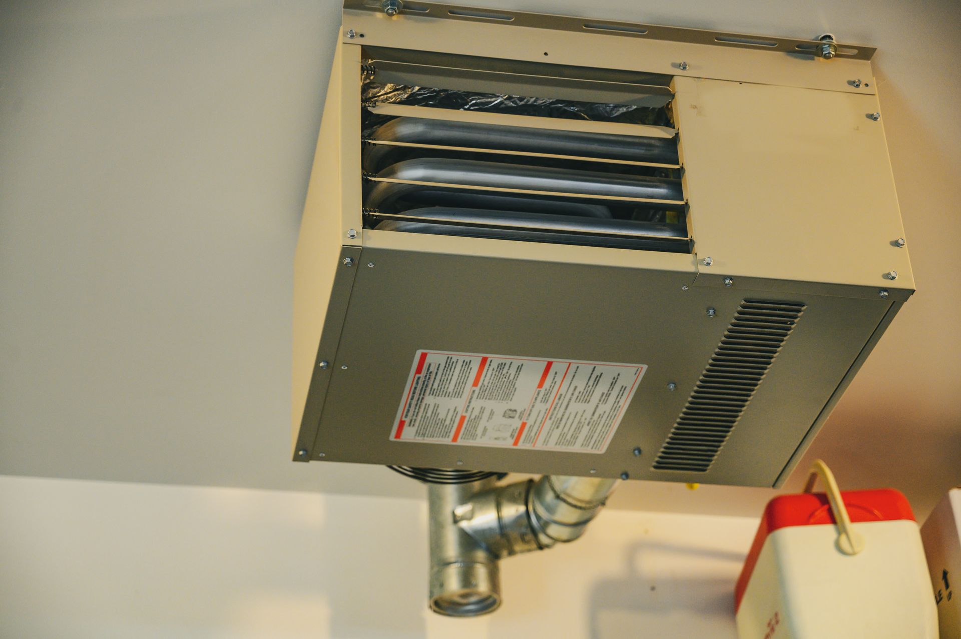 a heater is hanging from the ceiling in a garage .