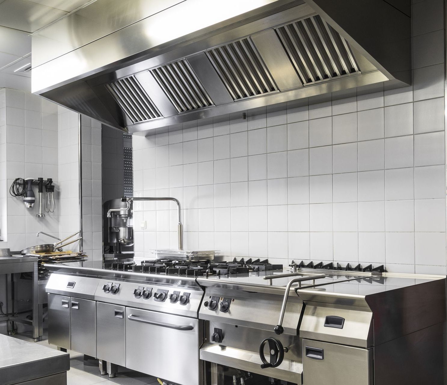 a kitchen with stainless steel appliances and white tiles