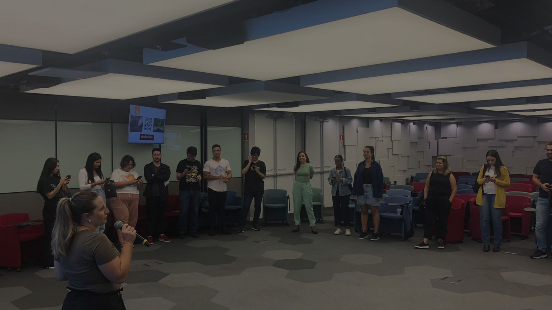 Um grupo de pessoas está em círculo em uma sala.