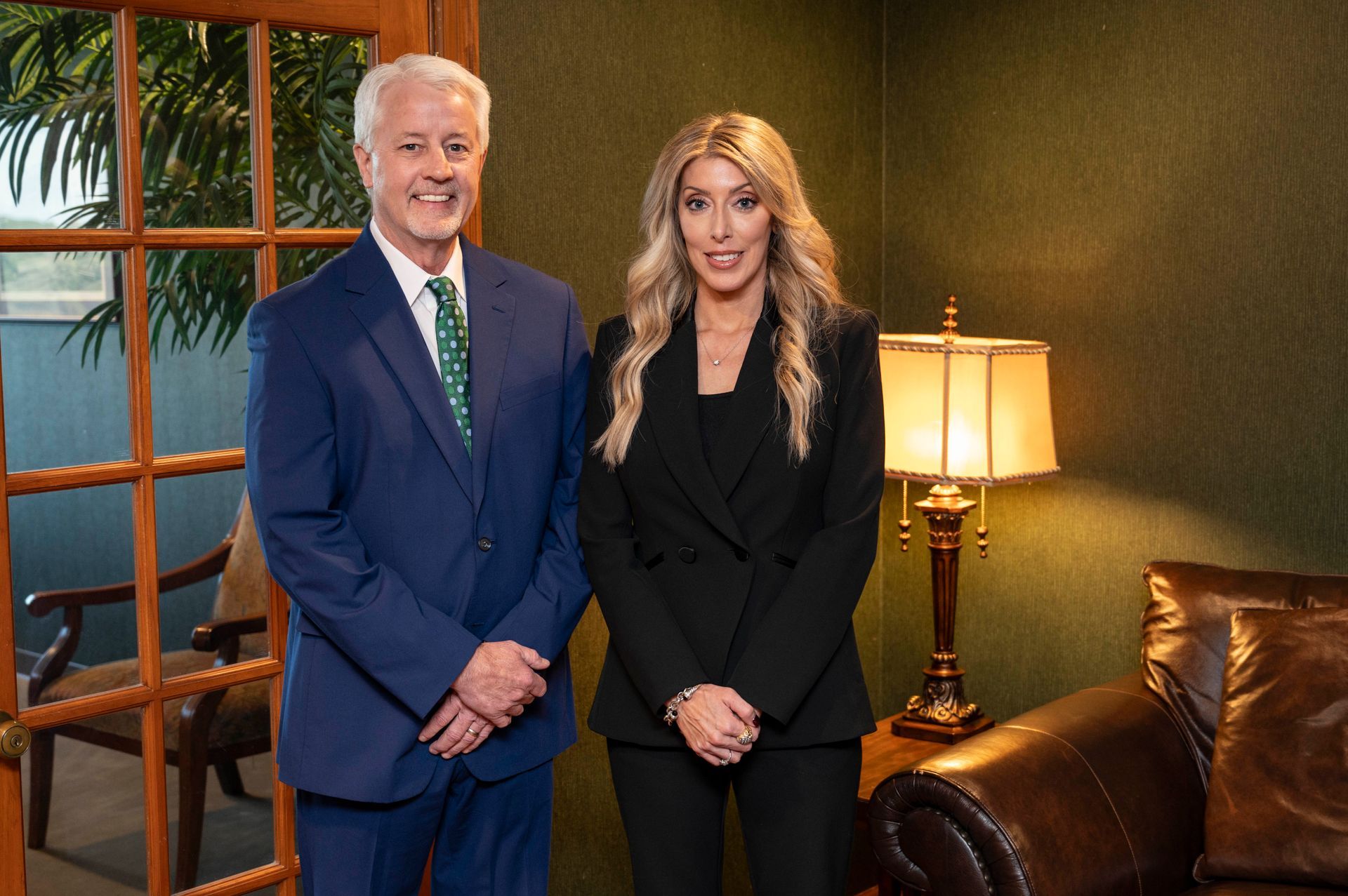 A man and a woman are standing next to each other in a living room.