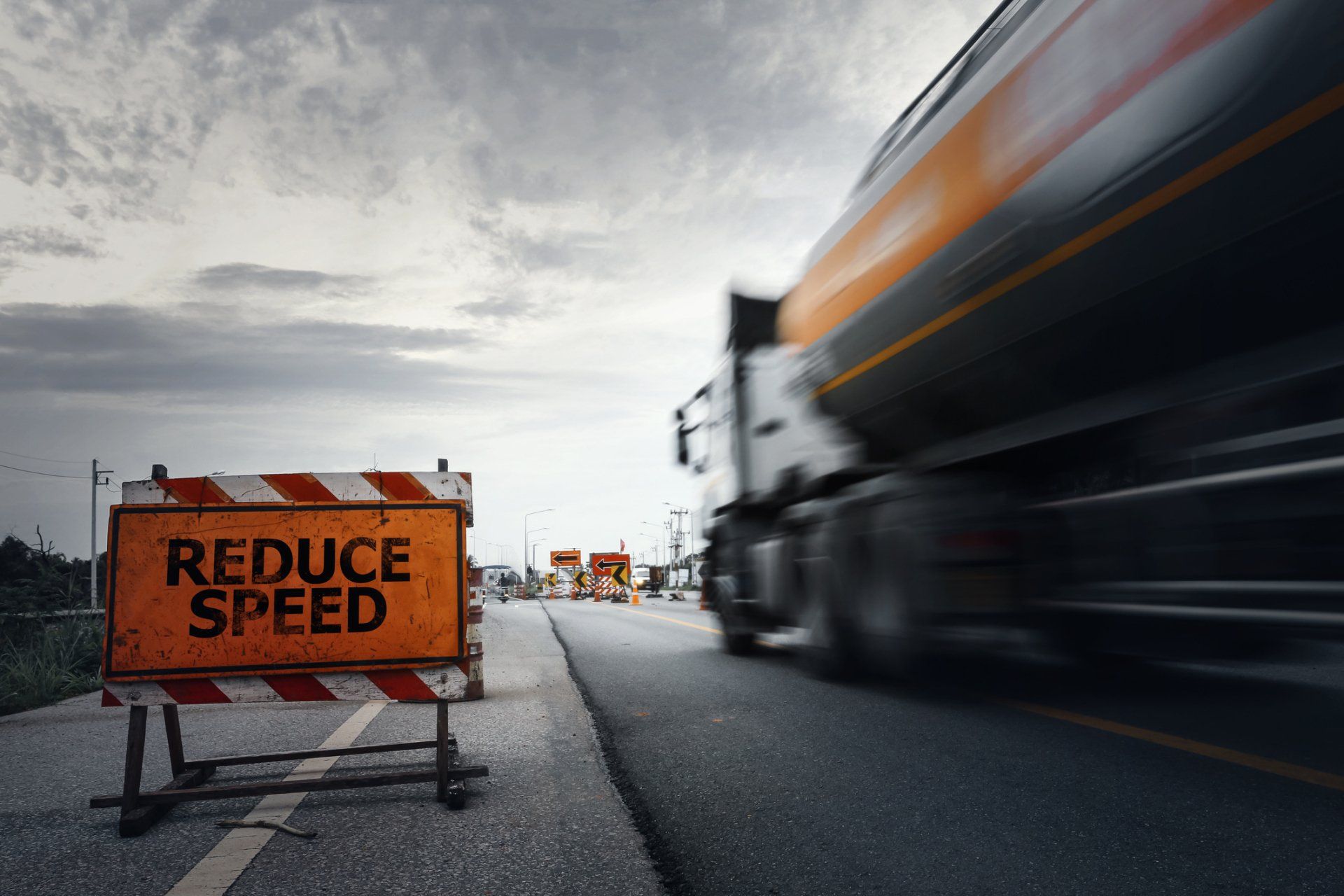 A sign on the side of a road that says reduce speed