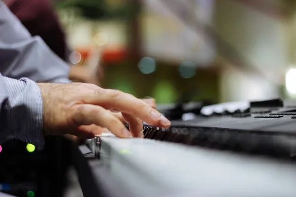 A close up of a person playing a keyboard.