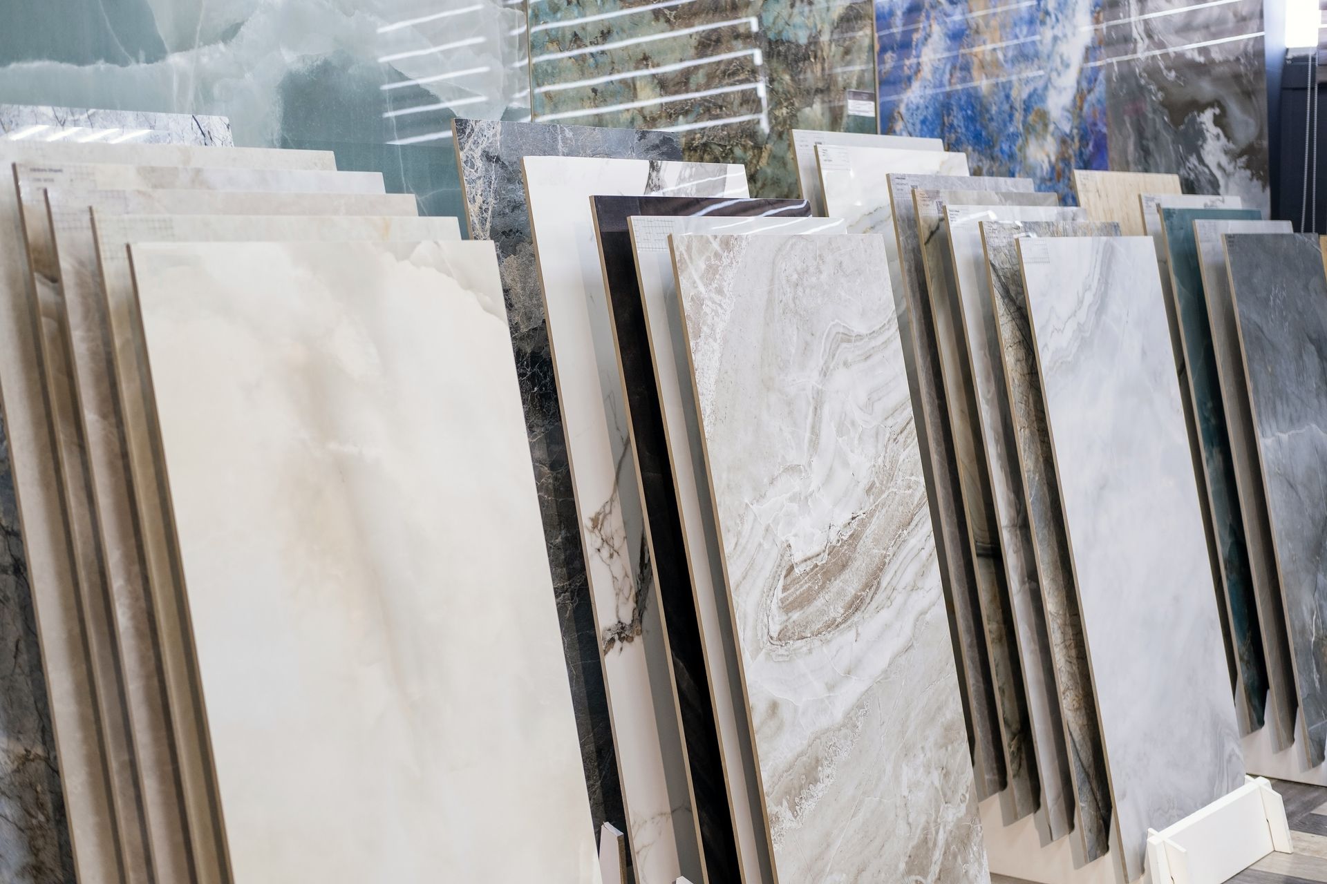 Rows of large white and gray stone slabs displayed outdoors in a yard.
