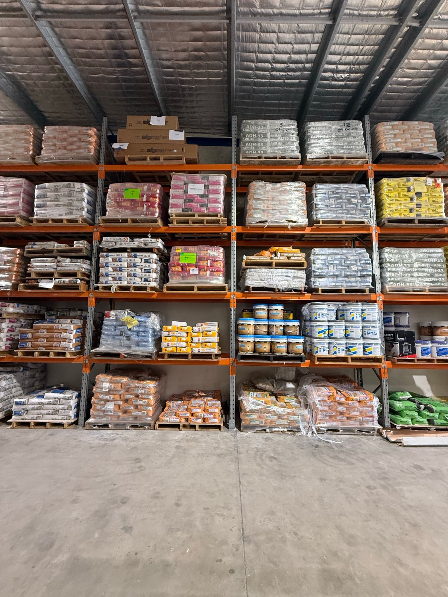 Warehouse shelves stacked with wrapped pallets and boxes of assorted goods