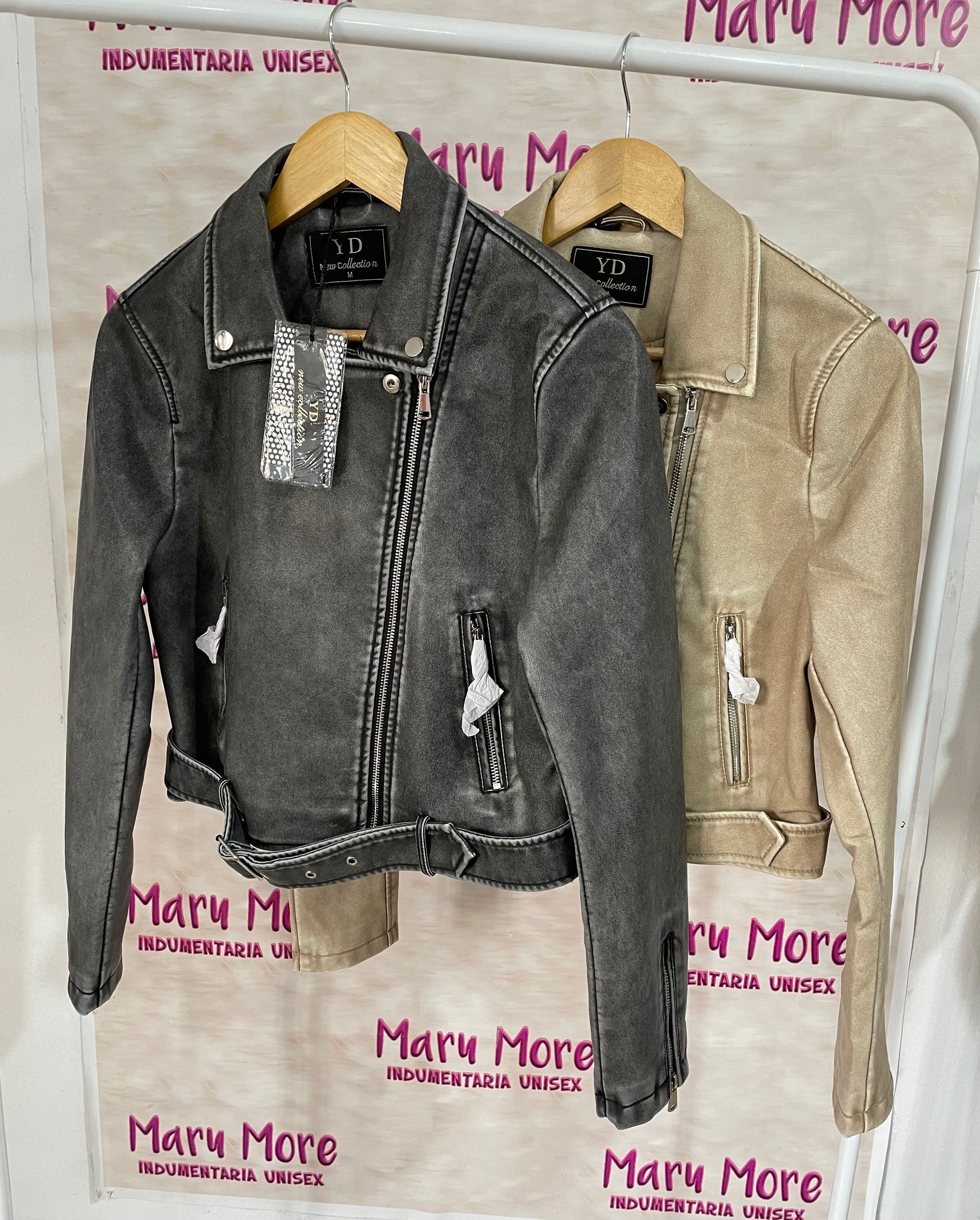Dos chaquetas están colgadas en un perchero en una tienda.