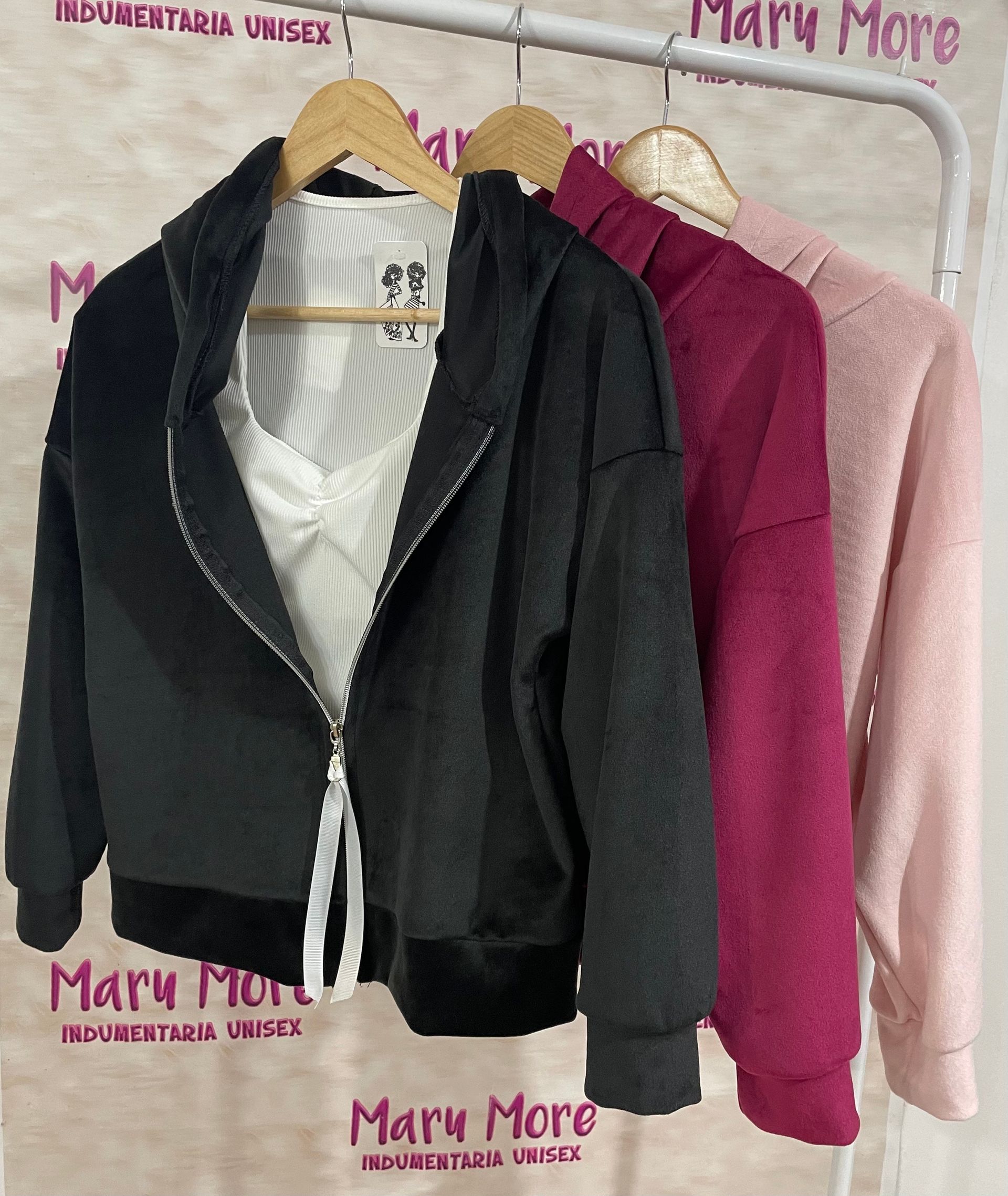 Una fila de chaquetas colgadas en un perchero con la palabra Mary More en la pared detrás de ellas.