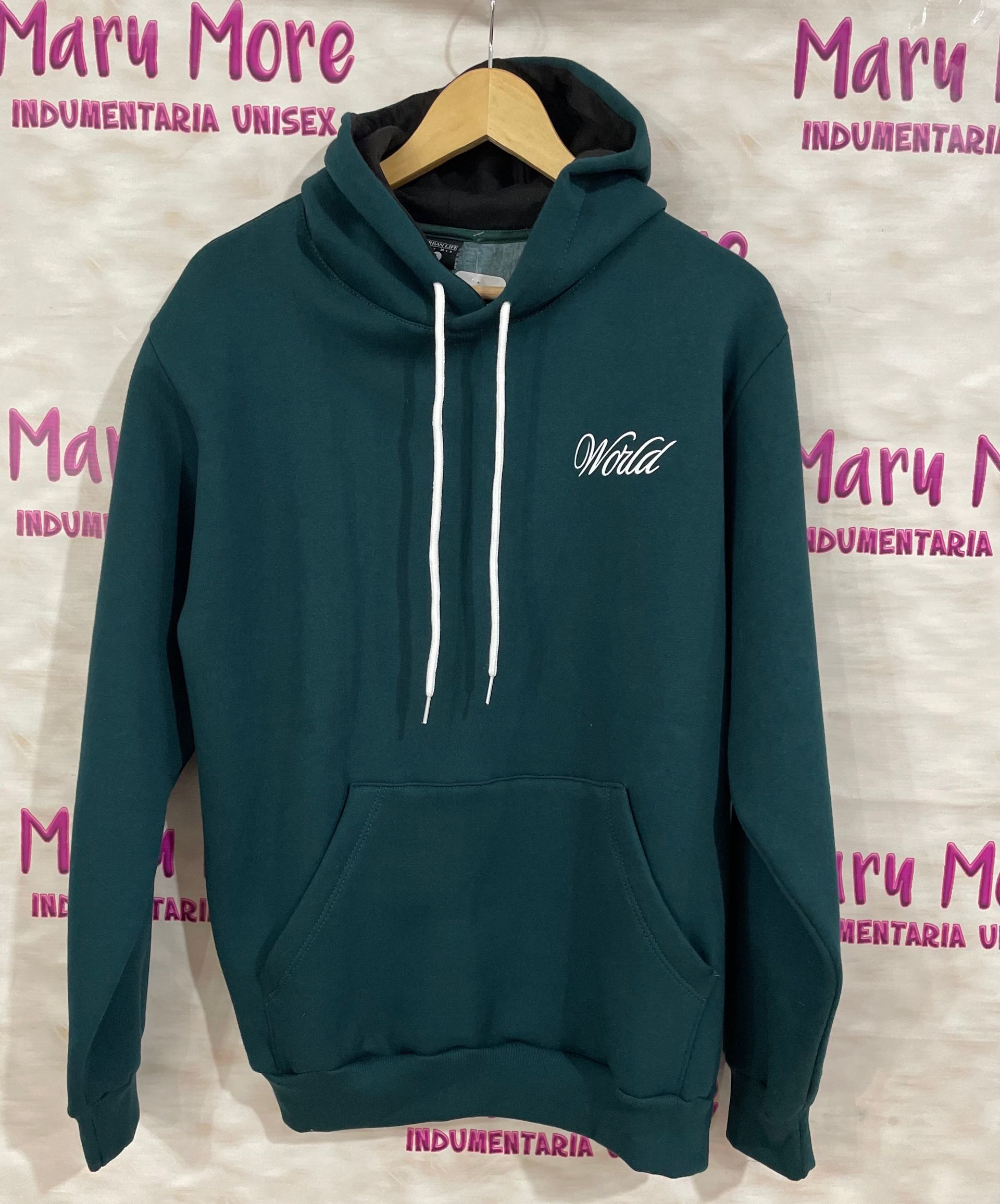 Una sudadera con capucha verde cuelga de una percha frente a un cartel que dice maru more