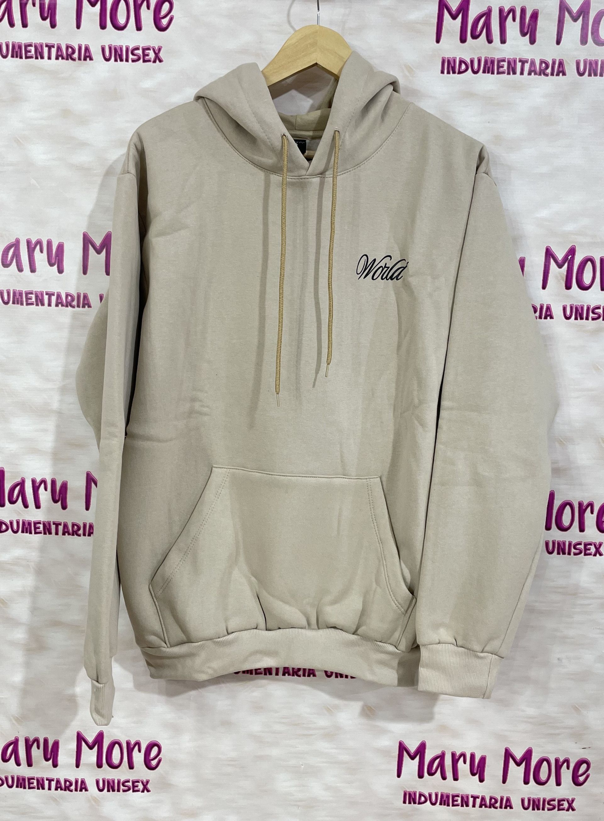 Una sudadera con capucha está colgada en una percha frente a un cartel que dice Mary More.