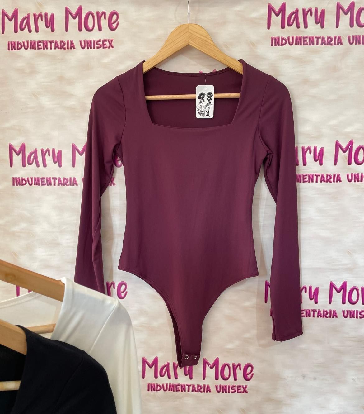 Un traje morado con mangas largas está colgado en una percha.