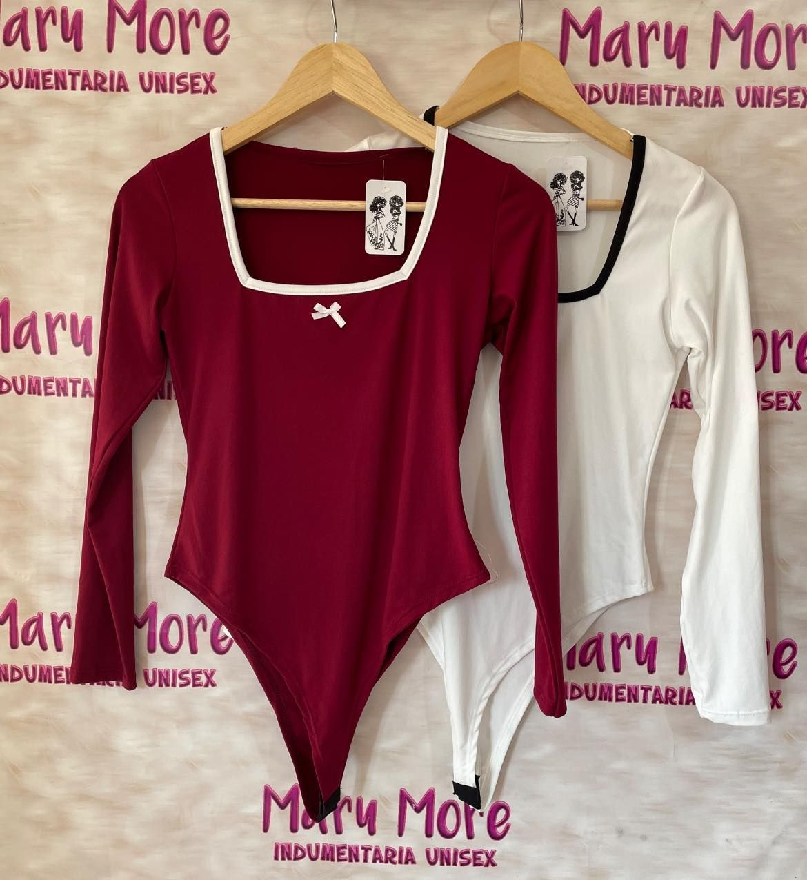 Tres camisetas están colgadas delante de un cartel que dice Mary More.
