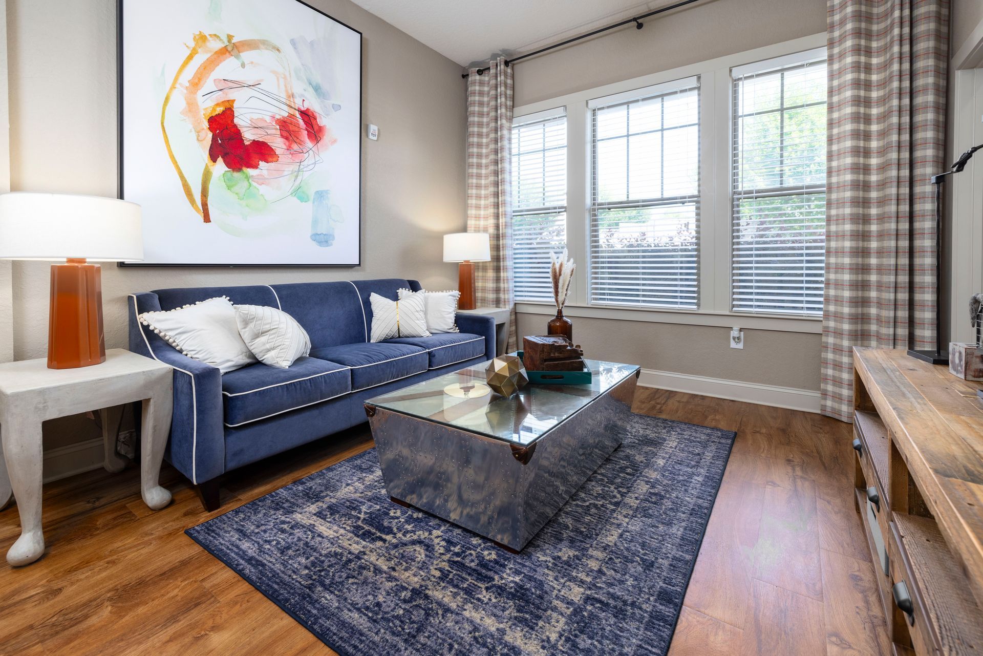 A living room featuring a blue sofa, a metallic coffee table, at Silver Collection at the Park.