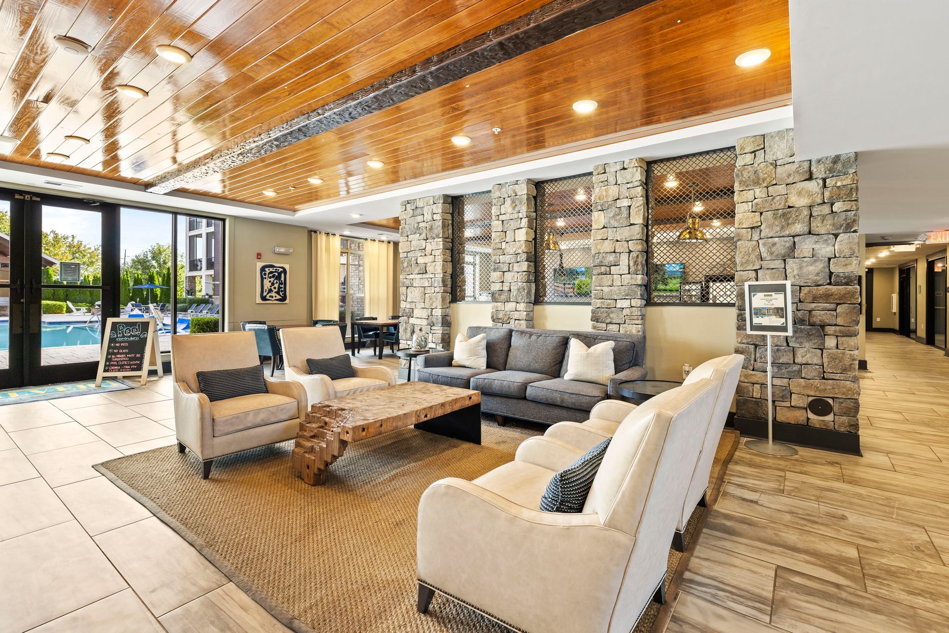 Lounge area with stone accent walls, a wooden ceiling, and soft seating at Silver Collection at the Park.