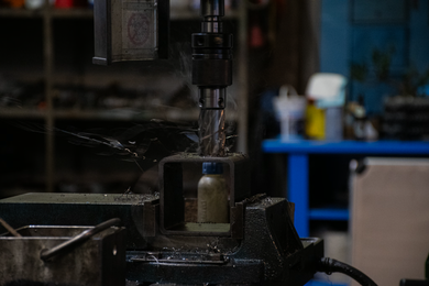 Tornio manuale in officina con particolare metallico in lavorazione