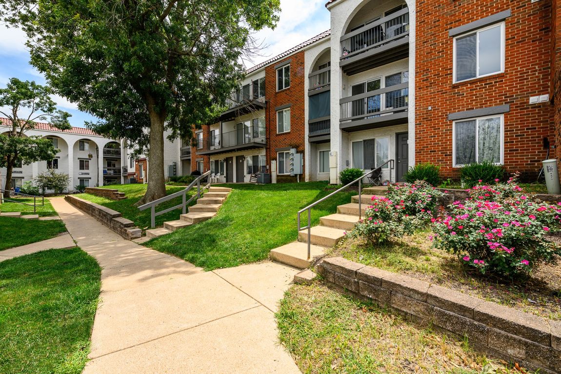A brick apartment building with stairs leading up to it
