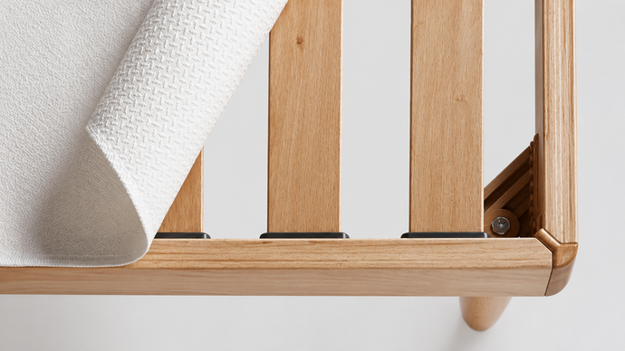 Soggiorno moderno con poltrona a fantasia, pouf marrone e parete rivestita in legno rustico.