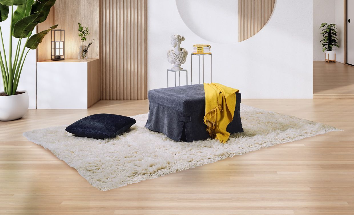 Soggiorno moderno con poltrona beige, tavolino basso e mensole nere accanto a una grande finestra.