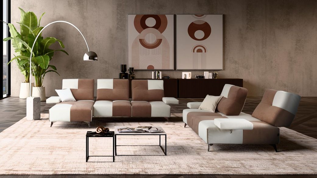 Divano componibile color crema con chaise longue su un tappeto verde in un soggiorno moderno, accanto a una finestra e una pianta.