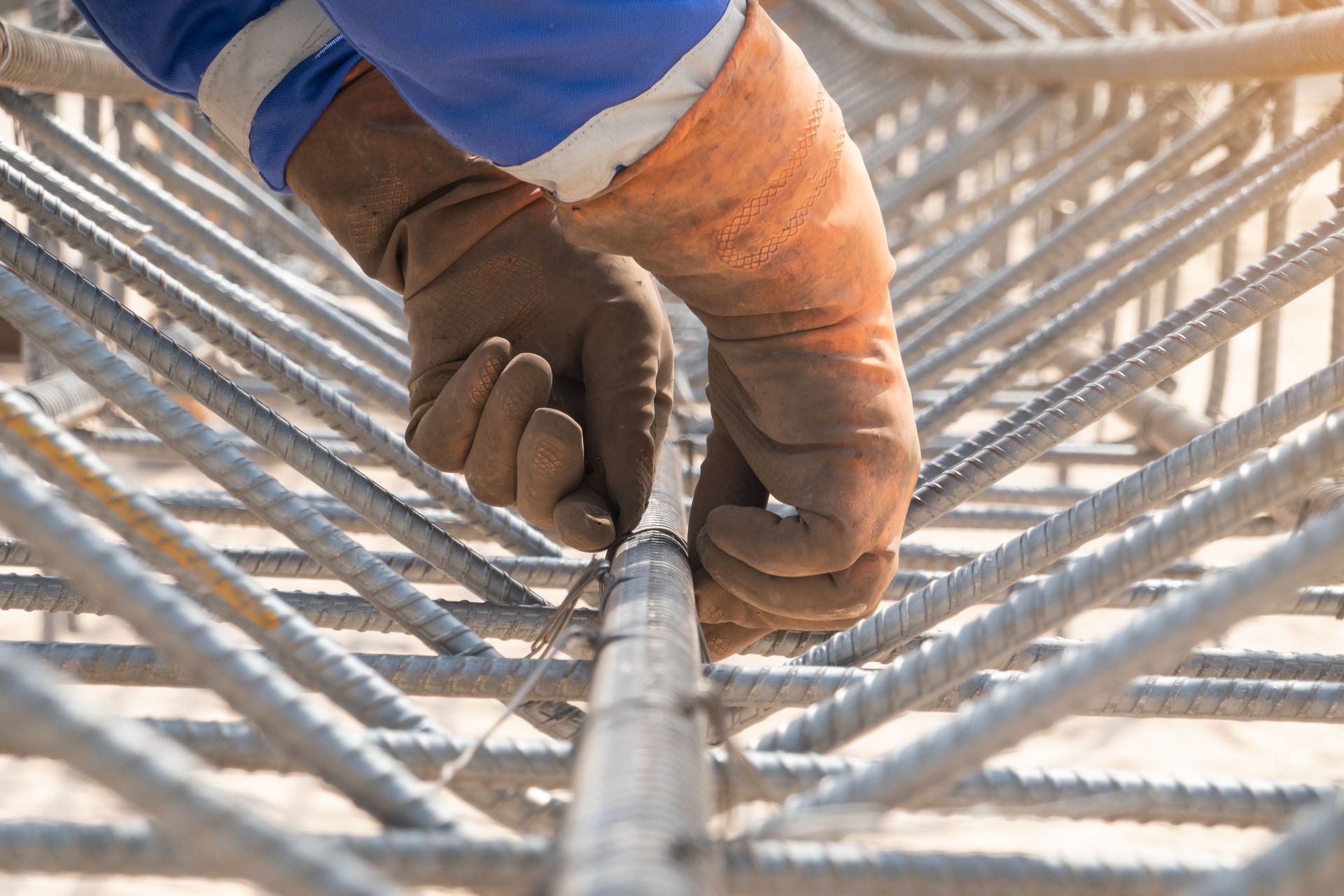 Contractor fixing a steel bar at a construction site, showcasing quality concrete formwork services. Contractor fixing a steel bar at a construction site, showcasing quality concrete formwork services.