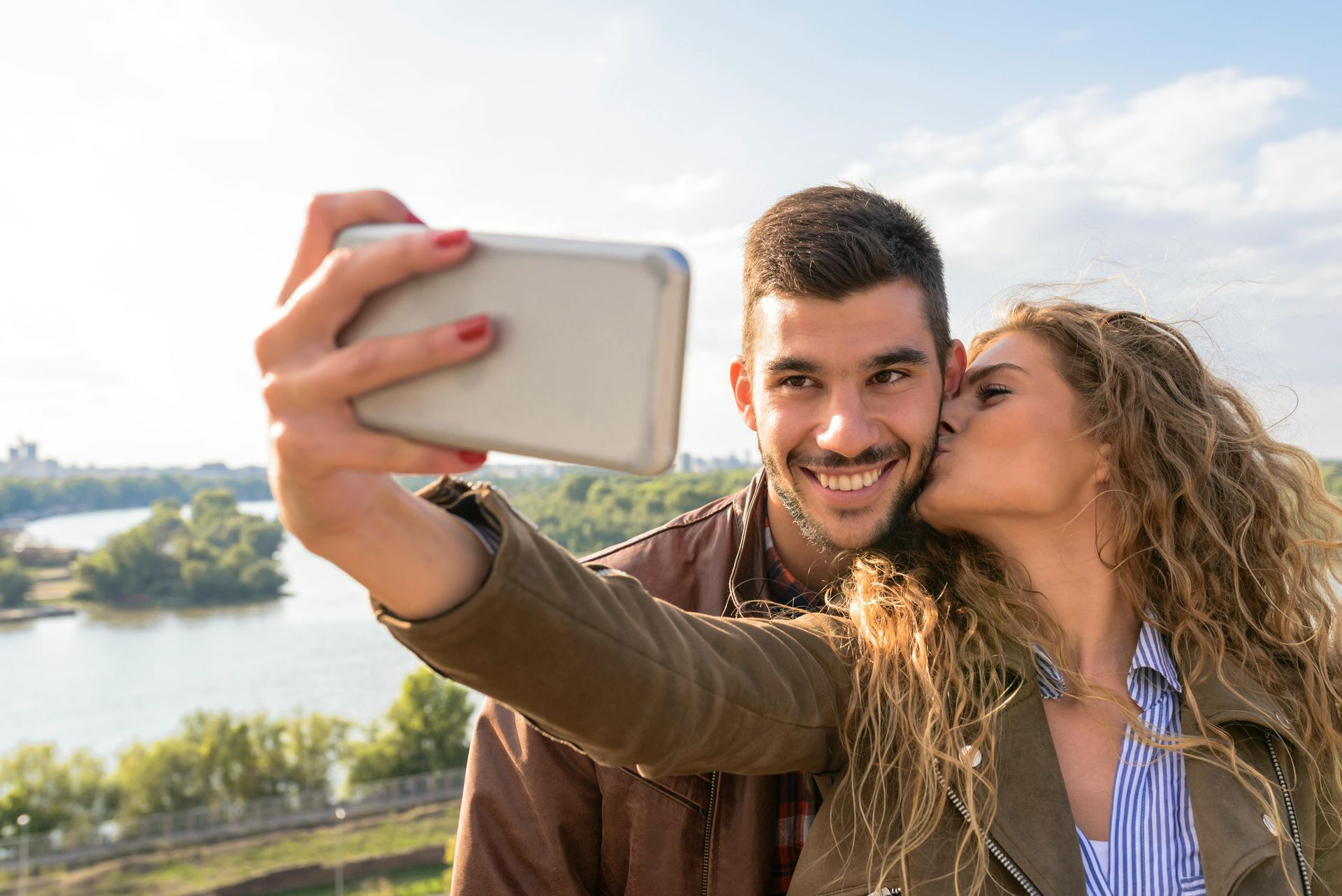 A man and a woman are taking a selfie with a cell phone.