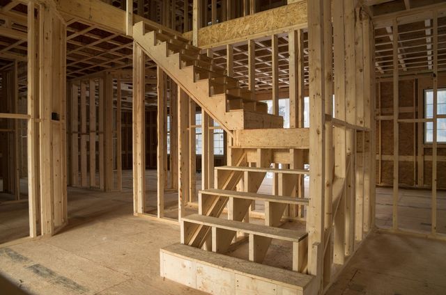 A wooden staircase in a house under construction.